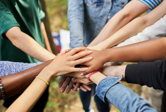 a group of people with their hands in the centre